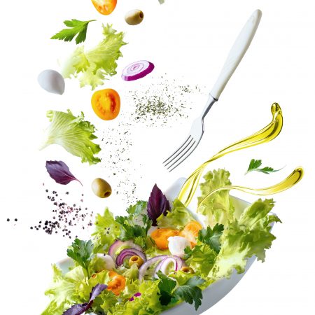 A white plate with salad and floating in the air ingredients: olives, lettuce, onion, tomato, ?ozzarella ?heese, parsley, basil and olive oil. Vegetarian menu. Copy space.